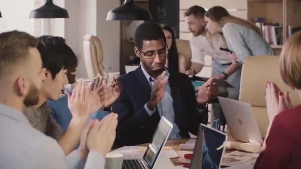 Feliz exitoso empresario afroamericano aplaude de la mano junto con sus colegas, celebrando el éxito del equipo en la reunión . — Vídeos de Stock