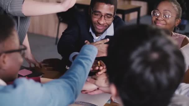 Счастливые воодушевленные мультиэтнические бизнесмены, взявшиеся за руки, празднуя победу корпоративной команды и успех на офисном собрании — стоковое видео