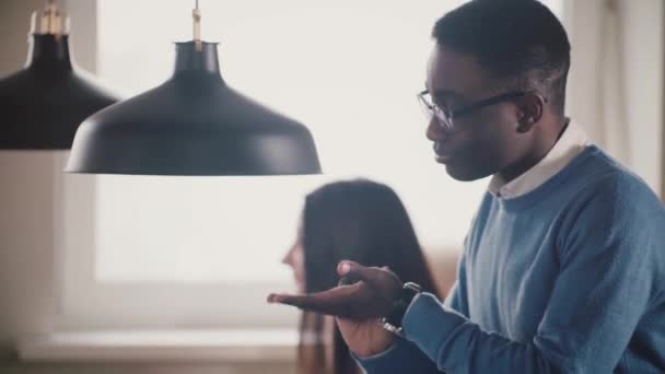 Primer plano del joven empresario afroamericano hablando, mostrando gestos, jugando con poco fútbol en la oficina moderna . — Vídeos de Stock