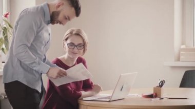İki genç Avrupa arkadaşlar trendy office masada tarafından işbirliği. Yakışıklı çalışan kadın patron ile düşünce paylaşımı.