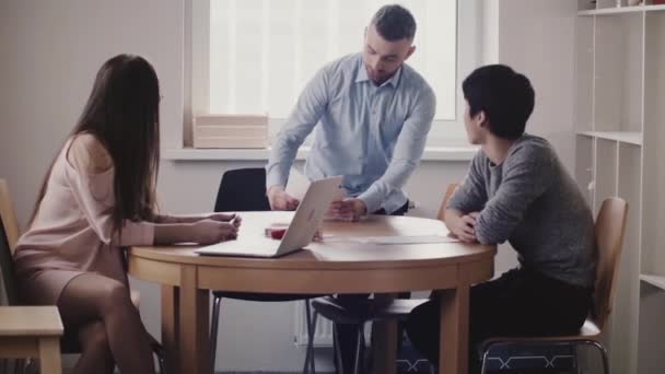 Hermosa mujer jefa escuchando al joven japonés en la entrevista de trabajo en la oficina moderna, empleado caucásico se une en . — Vídeo de stock