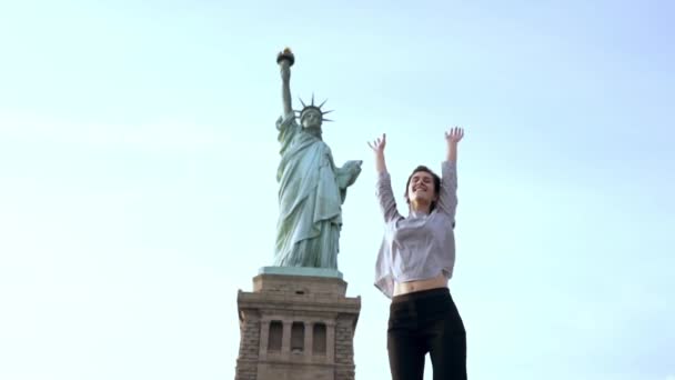 Успішний європейський жіночий позаштатний працівник високі стрибки з радістю, насолоджуючись доброго, що живуть в повільному статуя свободи. — стокове відео