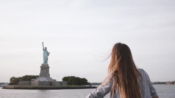 Joyeux succès femme d'affaires avec les cheveux soufflant dans le vent profitant épique Statue de la Liberté vue sur un bateau ralenti . — Video
