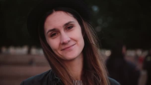 Joven feliz positivo relajado mujer europea en elegante sombrero negro con el pelo largo mirando a la cámara, sonriendo y posando . — Vídeo de stock