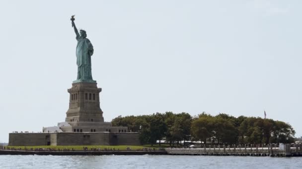 Ünlü bir yaz gününde New York ABD'de Liberty Adasında özgürlük ulusal anıt heykeli görüntülemek bir turist tekne. — Stok video