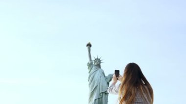 Güzel gülümseyen Avrupa turist kadın Anıtı New York'ta bir smartphone fotoğraf alır, fotoğraf makinesinin için