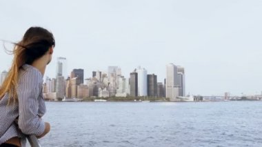 Bir turist tekneden New York'ta meşhur Manhattan skyline manzarayı saç uçan ile mutlu gülümseyen Avrupa kadın.
