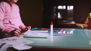 İleti örneği ile masada bir kalem ile kayma kamera küçük sevimli beyaz kız çocuk pembe kazak çizim yaptı.