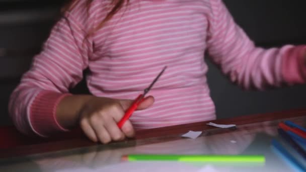 Primer plano de las niñas lindas manos en suéter rosa formas de papel de corte con tijeras y dibujo con un lápiz . — Vídeo de stock