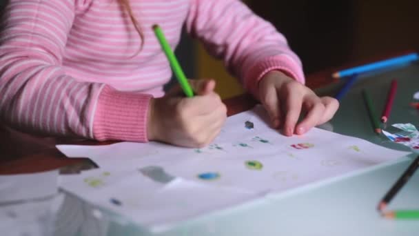 Κοντά shot της Καυκάσιος χαριτωμένο κοριτσάκι μάθηση με την ισοπαλία στο χαρτί, κρατώντας ένα μολύβι με ολόκληρο το χέρι στο σπίτι τραπέζι. — Αρχείο Βίντεο