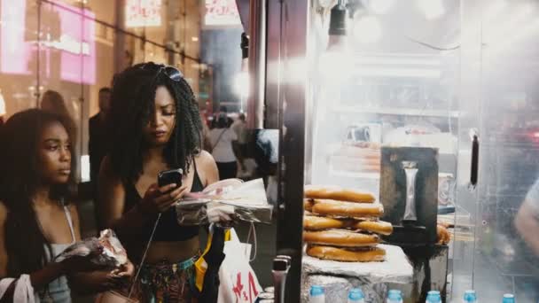 Нью-Йорк 18 серпня 2017 - два привабливі місцевих афро-американських молодих жінок купівлі вуличної їжі за допомогою смартфона в Нью-Йорку — стокове відео