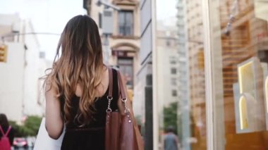 Kamera ağır çekim alışveriş sonra New York'ta Caddesi boyunca yürümeye genç başarılı işkadını izler.