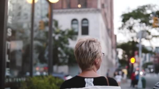 Cámara lenta dos jóvenes amigos felices caminan juntos hablando, sonriendo y explorando las calles nocturnas de la ciudad de Nueva York . — Vídeos de Stock