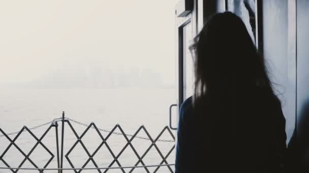 Silhouet van jonge vrouwelijke blogger op een boot van de tour naar Manhattan eiland genieten van uitzicht op de skyline van New York op een mistige dag. — Stockvideo