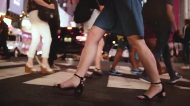 Atmosferik ağır çekim shot genç kadın bacak yoğun kalabalık cadde geceleri Times Square, New York'ta yürüme..