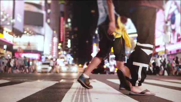 Fantastiska låg vinkel slowmotion skott av publiken gå tvärs över gatan med många annonser på natten på Times Square, New York. — Stockvideo