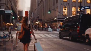 New York, Amerika şehir merkezinde trafik yol geçiş alışveriş torbaları ile yürüyen genç güzel kadın.