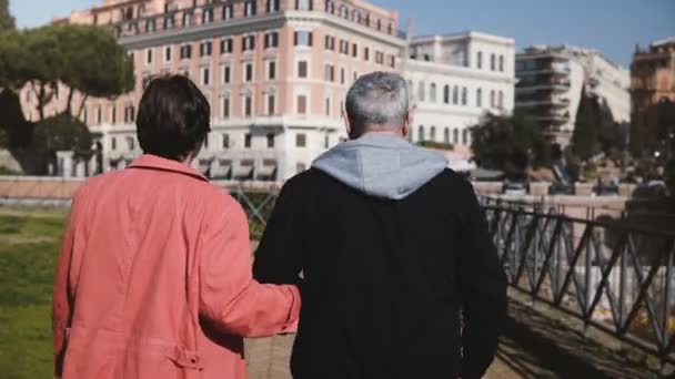다시 보기 사랑 스러운 로맨틱 수석 행복 한 커플 함께 초기 로마, 이탈리아에에서 휴가에 손을 잡고 산책. — 비디오