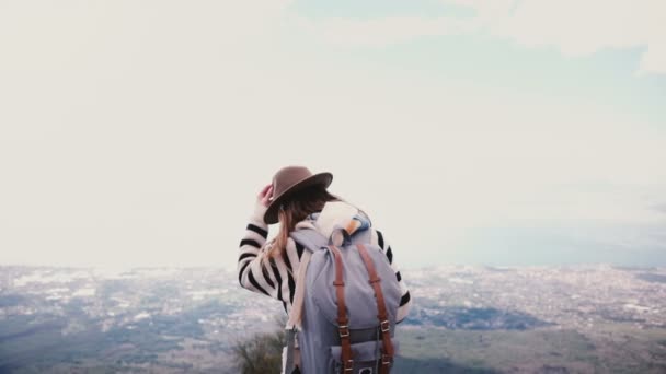 Entusiasmada bela turista segurando chapéu, virando-se para a câmera e sorrindo para a vista de paisagem épica montanha no topo em Vesúvio — Vídeo de Stock