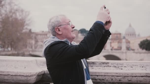 Heureux homme européen souriant prenant une photo smartphone de Rome, Italie en voyage de vacances à la retraite au ralenti . — Video
