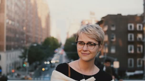 Close-up portret van gelukkige jonge Europese blond meisje met kort haar in brillen glimlachend en poseren bij camera buiten — Stockvideo