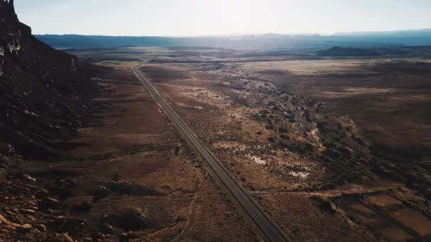 Filmische luchtfoto van epische wijd open woestijn woestijn van Arizona eindeloze woestijn vallei met auto verplaatsen langs snelweg — Stockvideo