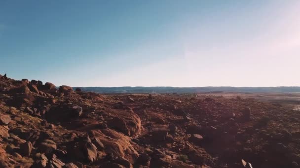 美国亚利桑那州日落时, 无人驾驶飞机在地面上低空飞行, 美砂岩景观覆盖着岩石和石块。. — 图库视频影像