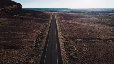 İleri düz çöl Otoban yol içinde büyük kayalık dağ ve güzel gökyüzü yakın ABD ekilmemiş boş arazi üzerinde uçan robot.