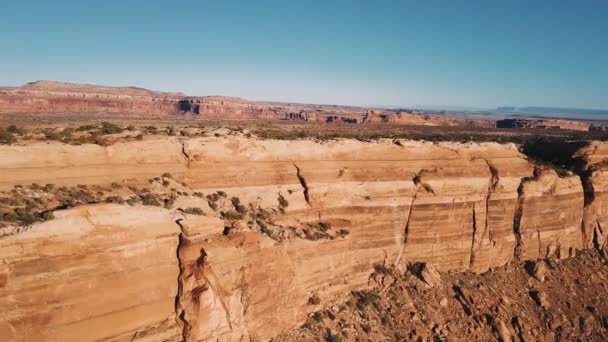 Drohnen-Schwenk links offenbart erstaunliches Panorama der flachen Bergschlucht mit steilen roten Felsformationen Skyline. — Stockvideo