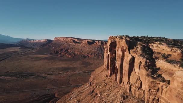 Drone voando muito alto perto de enorme cume de montanha deserto americano, ensolarado épico desfiladeiro falésias skyline no fundo . — Vídeo de Stock