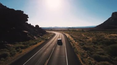 Drone kamera nefes kesen açık alanlarda ve dağlar arasındaki çöl Otoban yol üzerinde sola dönerek steyşın araba takip eder..