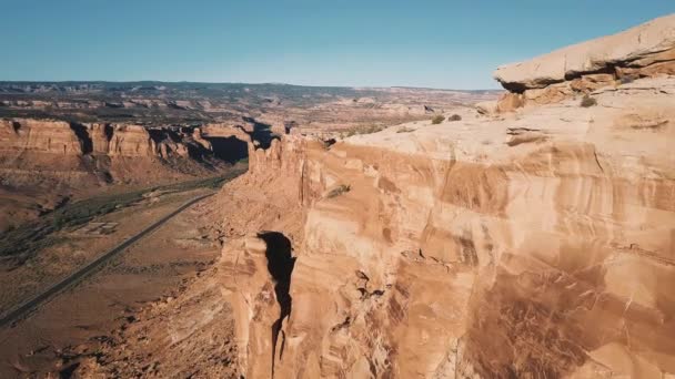 Drone che vola molto vicino alla grande cresta montuosa del deserto, maestose scogliere soleggiate del canyon americano sullo sfondo . — Video Stock