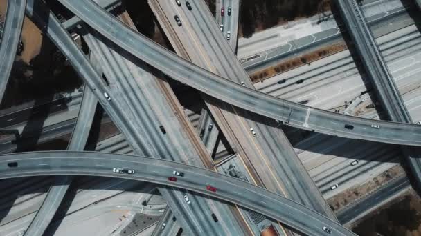 Drone ascendiendo y girando rápidamente por encima de la gran intersección de carreteras en Los Ángeles con coches en múltiples sobrevuelos . — Vídeo de stock