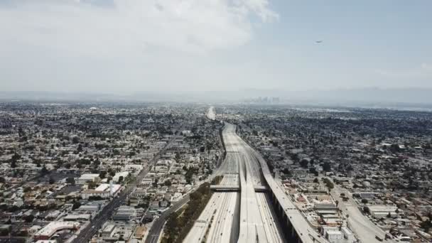 Drone descendiendo sobre increíbles suburbios de la ciudad americana, el tráfico se mueve en una gran carretera con un increíble intercambio de conexiones . — Vídeos de Stock