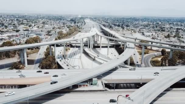 Drone, pohybující se zpět přes křižovatku obrovské dálnice v Los Angeles s auty prochází mnoha křižovatek a mosty. — Stock video