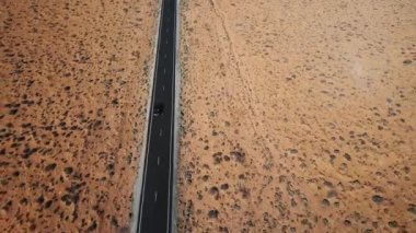 Drone gümüş renkli araba kavramı küresel ısınma ve erozyon kuru Amerikan çöl manzara otoyol sürüş izler.
