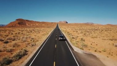 Drone aşağıdaki iki araba Anıt Vadisi, geniş güzel Otoban yol sürüş sonsuz kuru çöl manzara açın.