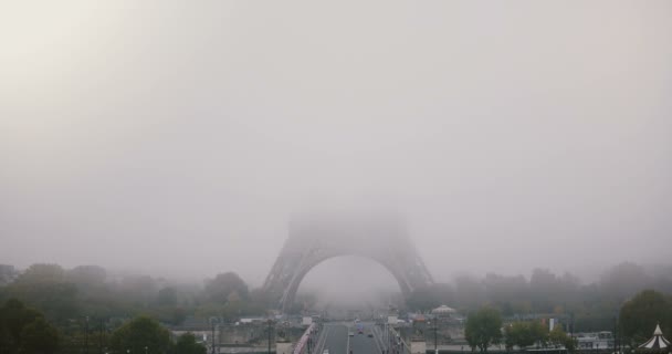 Timelapse van mistige Eiffeltoren. Parijs, Frankrijk. Atmosferische mystieke achtergrond openen van 4k. Straat verkeer. Slecht weer. — Stockvideo