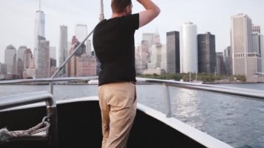 Şaşırtıcı New York skyline bir nehir tur tekne yavaş hareket üzerinde zevk açık kollu yakışıklı heyecanlı seyahat adam.