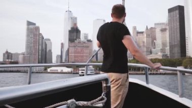 Mutlu heyecanlı turist adam Manhattan Adası cityscape manzarası görünümü bir tur tekne açık yavaş hareket üzerinden hayran.