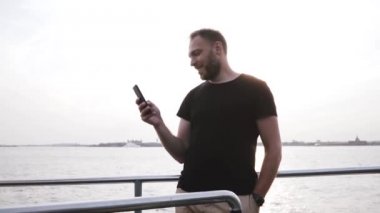Bir güzel gün batımı tekne gezisi ağır çekim etrafa smartphone, kullanarak mutlu başarılı beyaz girişimci.
