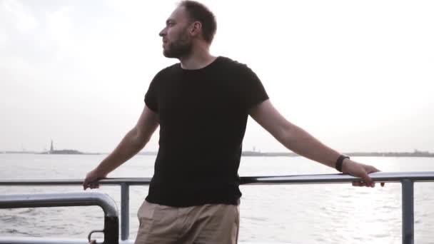 Feliz joven exitoso hombre de negocios sonriendo, disfrutando de la pacífica y hermosa noche en el mar en un barco privado de cámara lenta . — Vídeo de stock