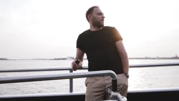 Happy European male traveler making a video using smartphone on a private boat evening sunset leisure trip slow motion. — Stock Video