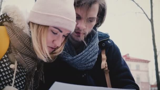 Close-up baixo ângulo tiro de turista homem e mulher estressado e perdido, olhando para um mapa da cidade tentando navegar no dia frio — Vídeo de Stock