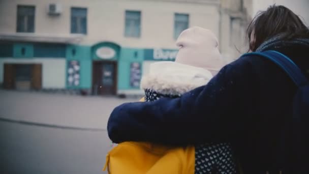 后视图愉快放松年轻浪漫夫妇在休闲温暖的衣服走在一起拥抱在一个下雪寒冷的冬天天. — 图库视频影像