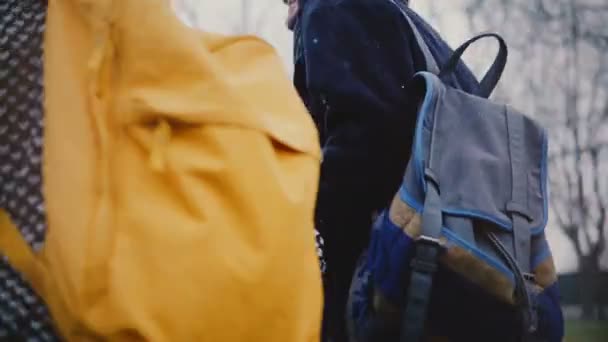 Камера движется вокруг счастливой расслабленной молодой романтической пары туристов с случайными рюкзаками ходить вместе в зимний день . — стоковое видео