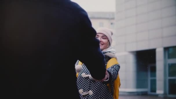 Slow motion happy smiling young European girl in winter clothes walks outside on a date with her boyfriend holding hands — Stock Video