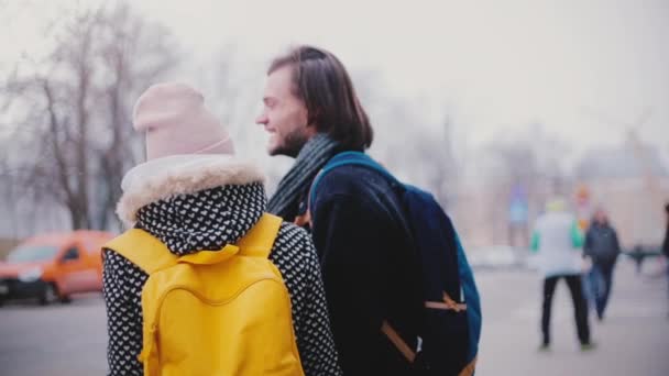 两个快乐的轻松的白种人朋友, 男人和女人, 站在一起, 在街上谈论在寒冷的雪冬天 — 图库视频影像