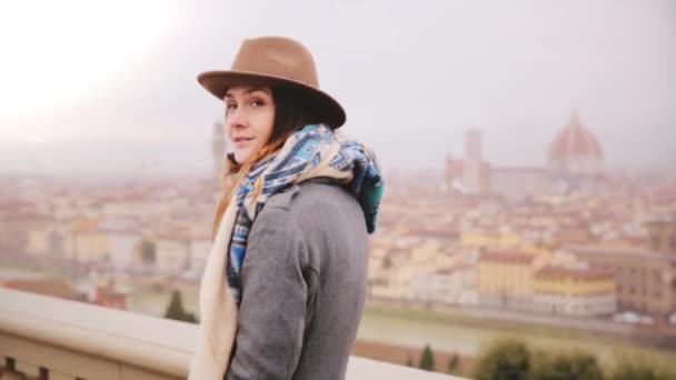 Menina turística feliz em pé chapéu e desfrutar de uma vista panorâmica incrível de Florença, Itália, olhando ao redor no dia chuvoso . — Vídeo de Stock