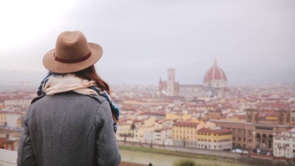 Happy young female traveler walks up, taking smartphone photo of amazing cityscape panorama of autumn Florence, Italy. — Stock Video